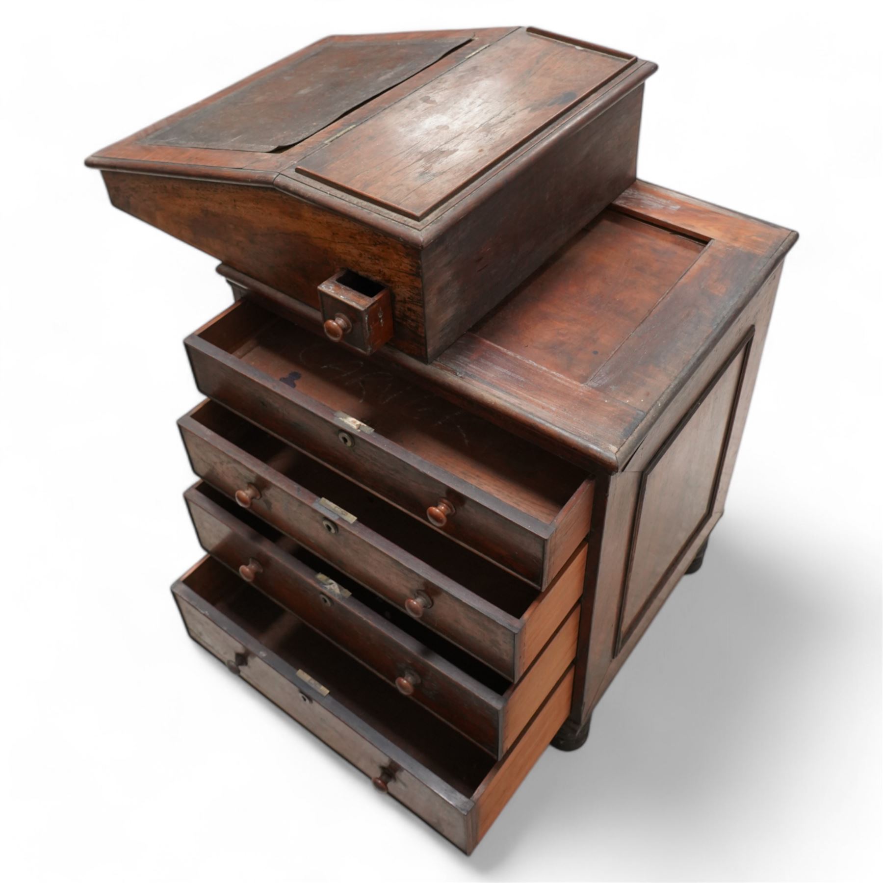 Early 19th century rosewood Davenport, sliding top section enclosed by moulded lid with leather inset, the interior fitted with single drawer, four graduating cock-beaded drawers to the right hand side and four false drawers to the opposing side, on turned feet 