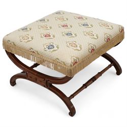 Regency mahogany stool, square seat upholstered in ivory ground floral patterned fabric with gilt thread and fringing, raised on a curved X-framed base united by ring turned supports