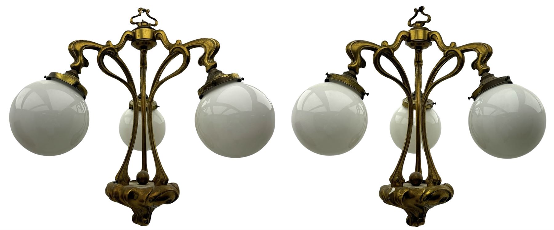 Pair of Art Nouveau design gilt metal ceiling lights, each with three stems connecting glass dome