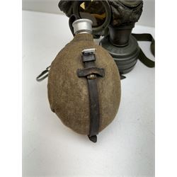 Two WWII German army canteen water bottles, together with German gas mask marked FE55 in a green fluted tin canister