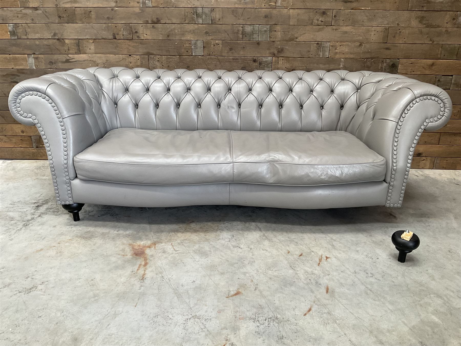 Three seat Chesterfield sofa, upholstered in grey buttoned leather - damaged leg