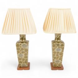 Pair of table lamps, decorated with flowers upon a green grounds, with a wooden base, H64cm