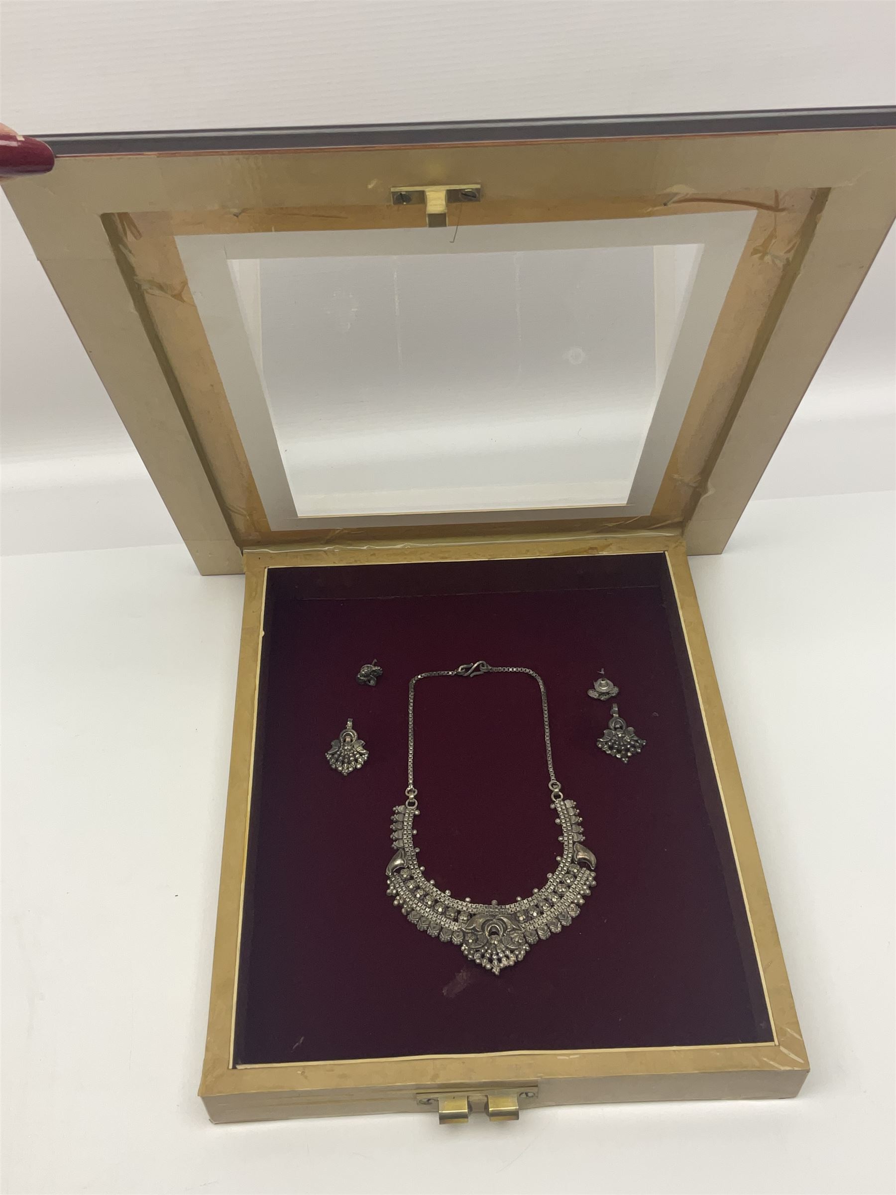 Framed Omani silver dhow sailing boat and a necklace and earring set, both in hinged wooden frames, max frame H33cm