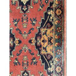 Northwest Persian salmon ground runner, the field decorated with a series of geometric medallions, surrounded by a multi-band border with floral motifs