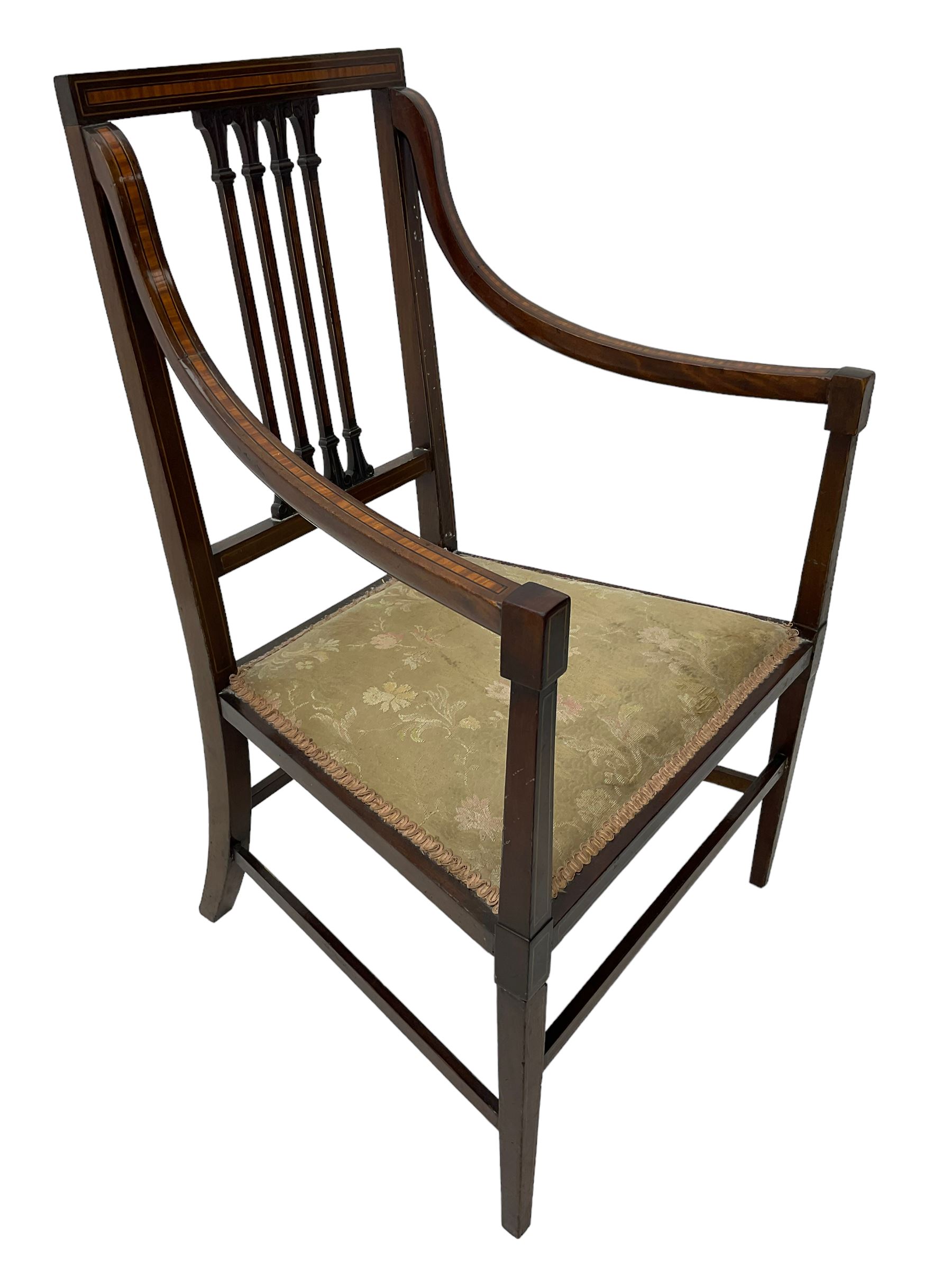 Edwardian satinwood inlaid mahogany elbow chair, the bar back over four vertical rails with foliate and scroll carved decoration, curved and down-swept arms, on square tapering supports united by stretchers 