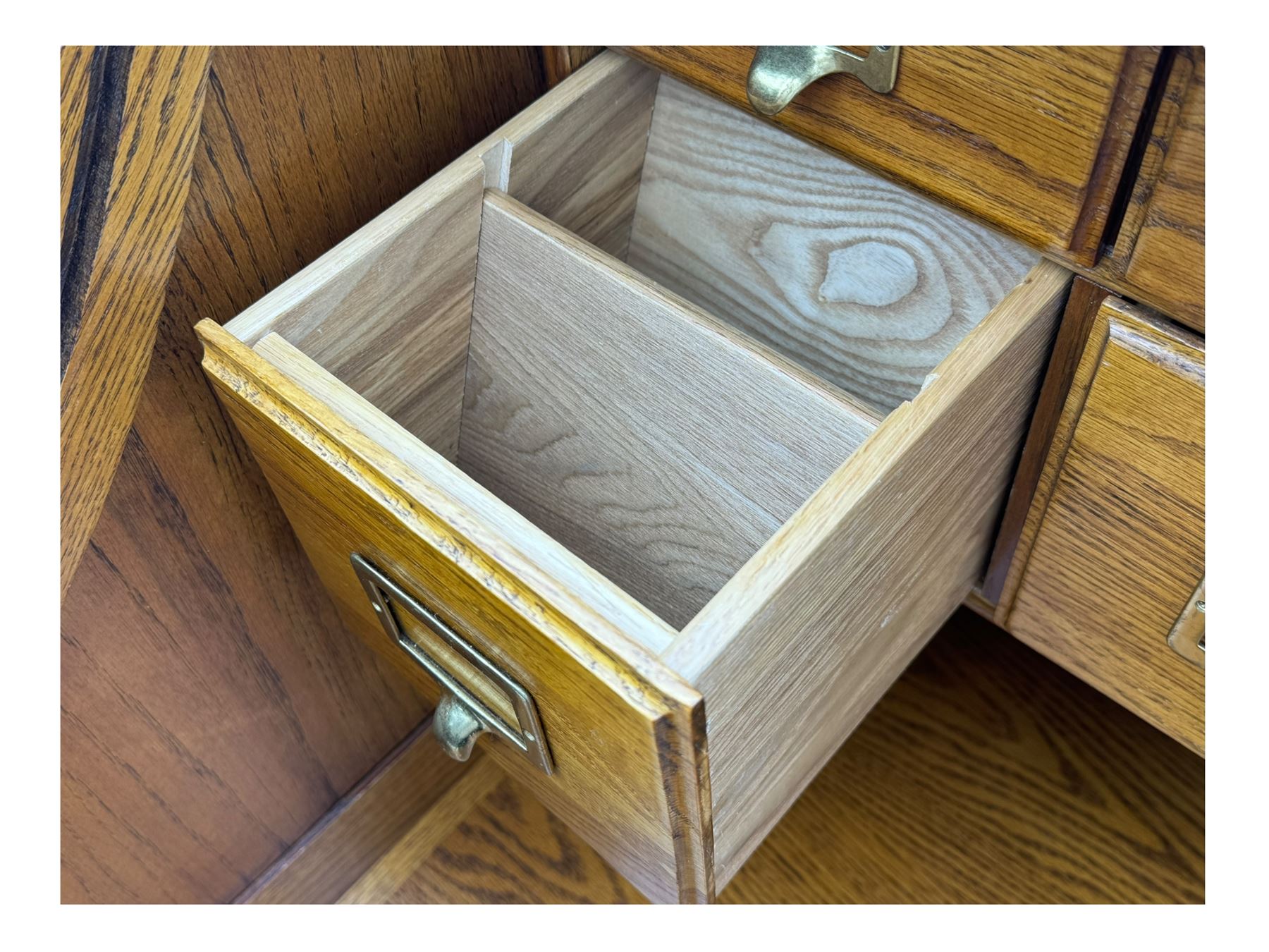 Early 20th century oak tambour roll-top desk, the top with fitted interior including drawers, pigeonholes and compartments, the twin pedestals fitted with four drawers with carved handles, supported by plinth base 