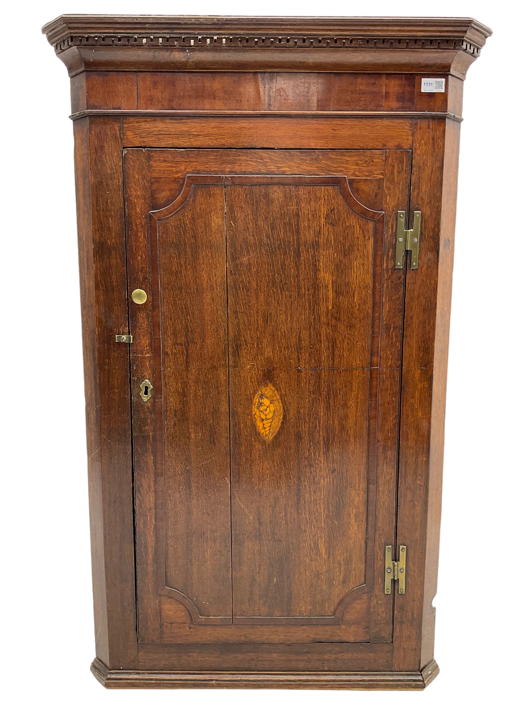 George III oak and mahogany wall hanging corner cupboard, single door decorated with central inlaid shell motif enclosing three shelves