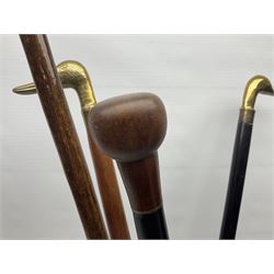 Eight walking sticks, including examples with carved pommels, brass handles, horn etc, in a ceramic stick stand with floral sprigs 