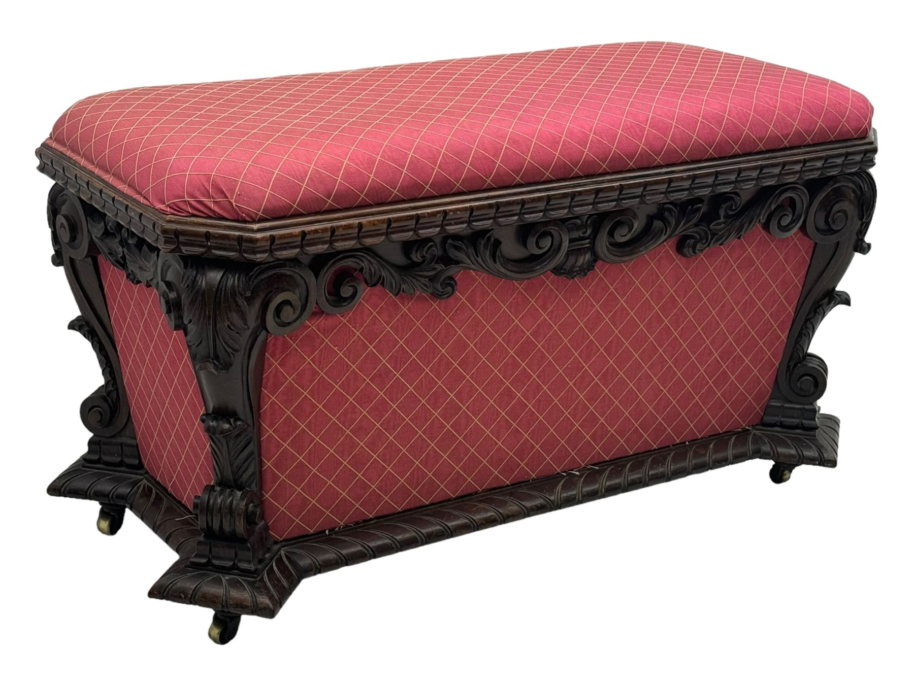 19th century rosewood and simulated rosewood ottoman footstool, tapering canted rectangular form enclosed by hinged lid, upholstered in red fabric, the frieze decorated with scrolling leaves, each corner with scrolled acanthus leaf supports, projecting shallow gadroon moulded edge 