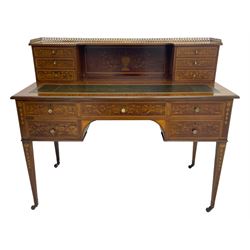 Edwardian inlaid mahogany writing desk, raised galleried back over inlaid central urn with scrolling leafy branches and six small drawers, satinwood banded rectangular moulded top with tooled leather inset, fitted with five drawers, the drawer facias inlaid with scrolling foliage and satinwood banding, square tapering supports inlaid with trailing bell flowers, on brass and ceramic castors 