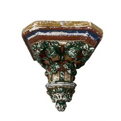 Two Victorian polychromed plaster cast corbels or wall brackets, canted rectangular tops over moulded edge and curled fruiting foliage