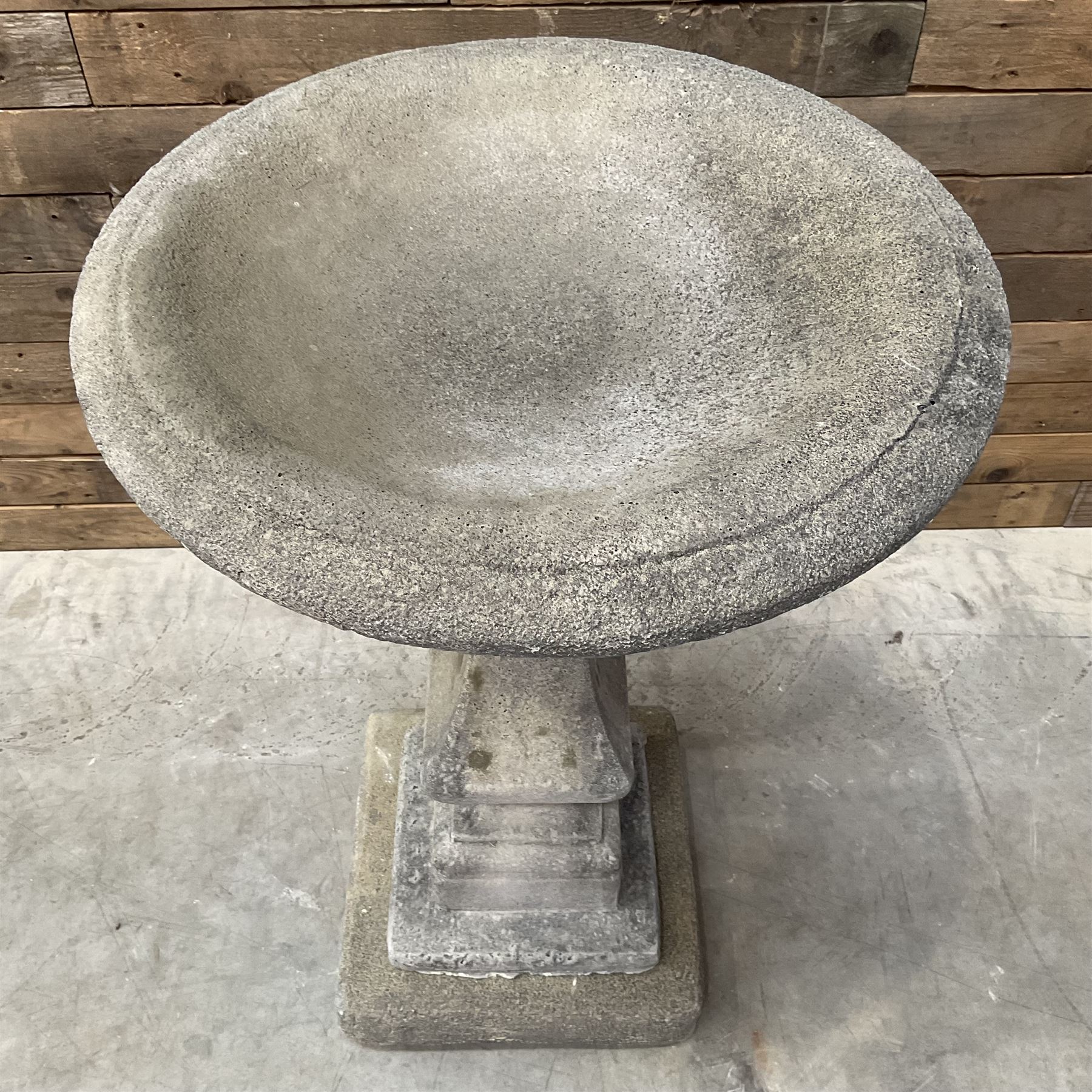 Cast stone garden bird bath, circular dished top, raised on square tapering column, on stepped base with separate mounting plinth