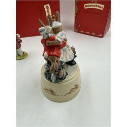 Two Royal Doulton Bunnykins music boxes, comprising Rocking Horse and Winter Waltz together with two Royal Doulton Bunnykins figures Once Upon a Time and Father, Mother & Victoria, all with original boxes  