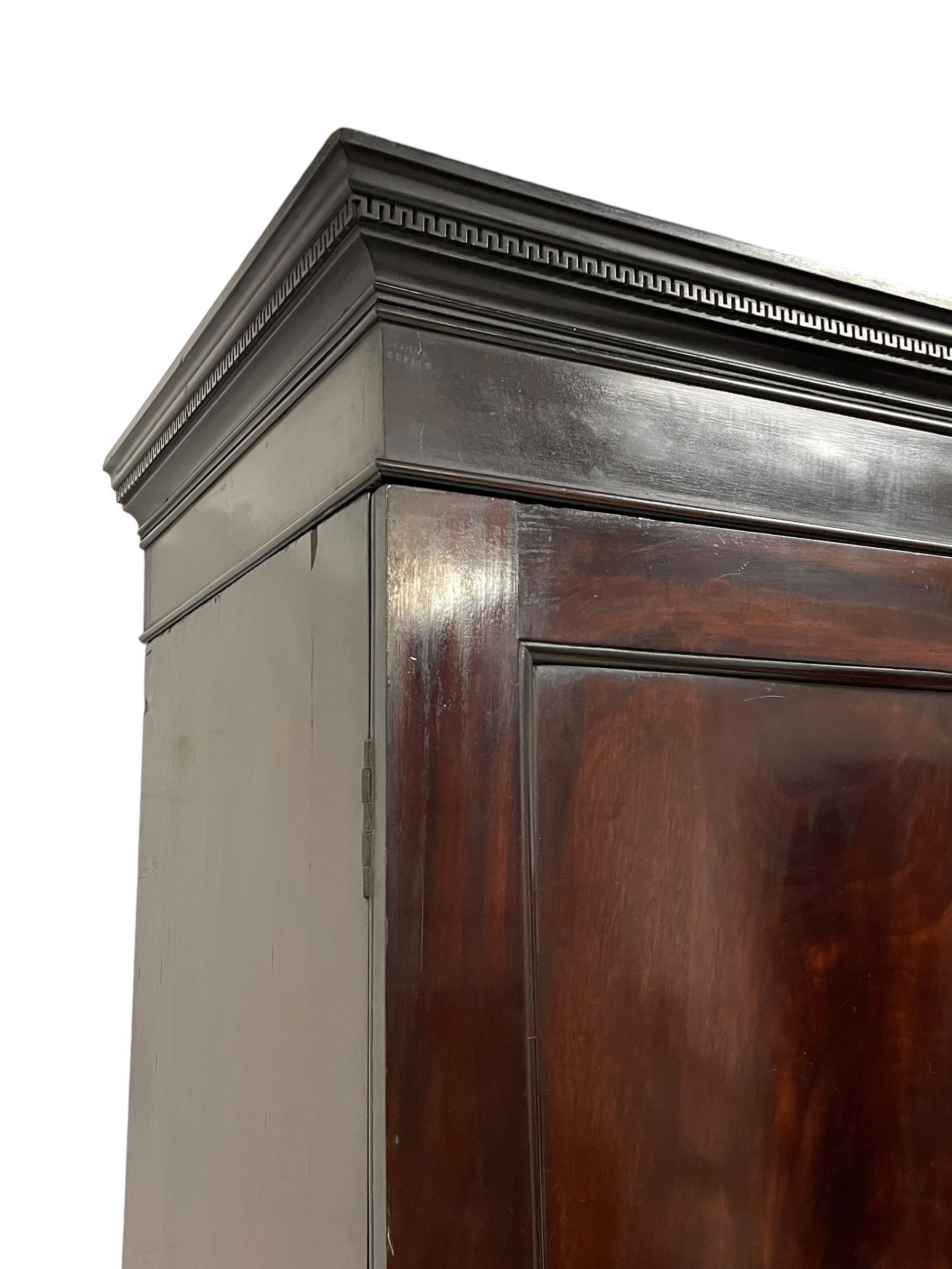 19th century Irish mahogany press wardrobe, projecting dentil cornice over two figured panelled doors, enclosing three sliding trays and hanging rail with coat hooks, fitted with two drawers to base over a shaped apron, raised on acanthus carved cabriole supports with paw feet, retailed by Millar & Beatty of Dublin, with paper labels verso, collected and restored by Michael Butler (1870-1900), impressed stamp to side and ink stamp to drawer inscribed 'M Butler collector of high-class furniture and works of art'