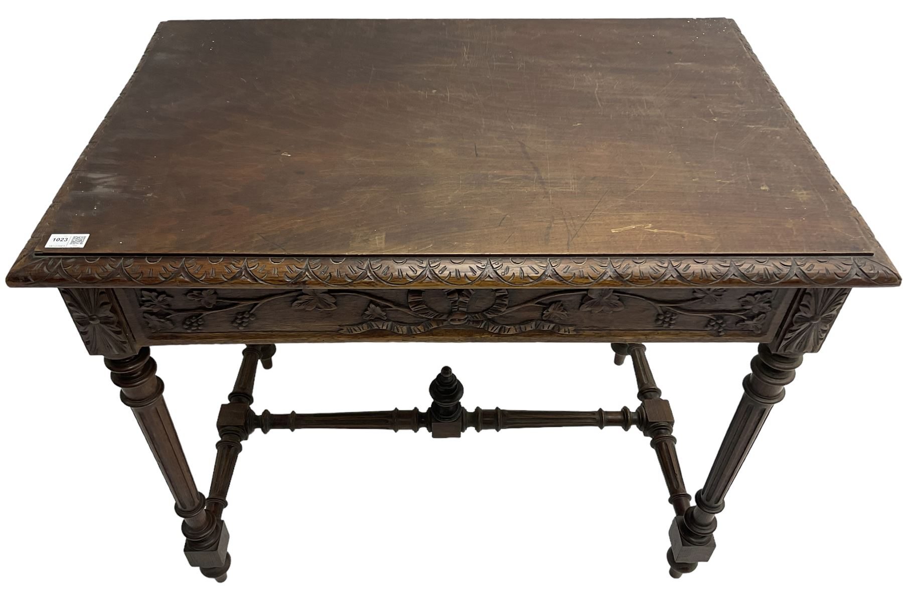 19th century walnut side table,  rectangular top with lunette carved moulded edge, the frieze drawer carved with ribbon and extending vine branch and grapes, on turned and fluted supports united by fluted stretcher with centre finial 