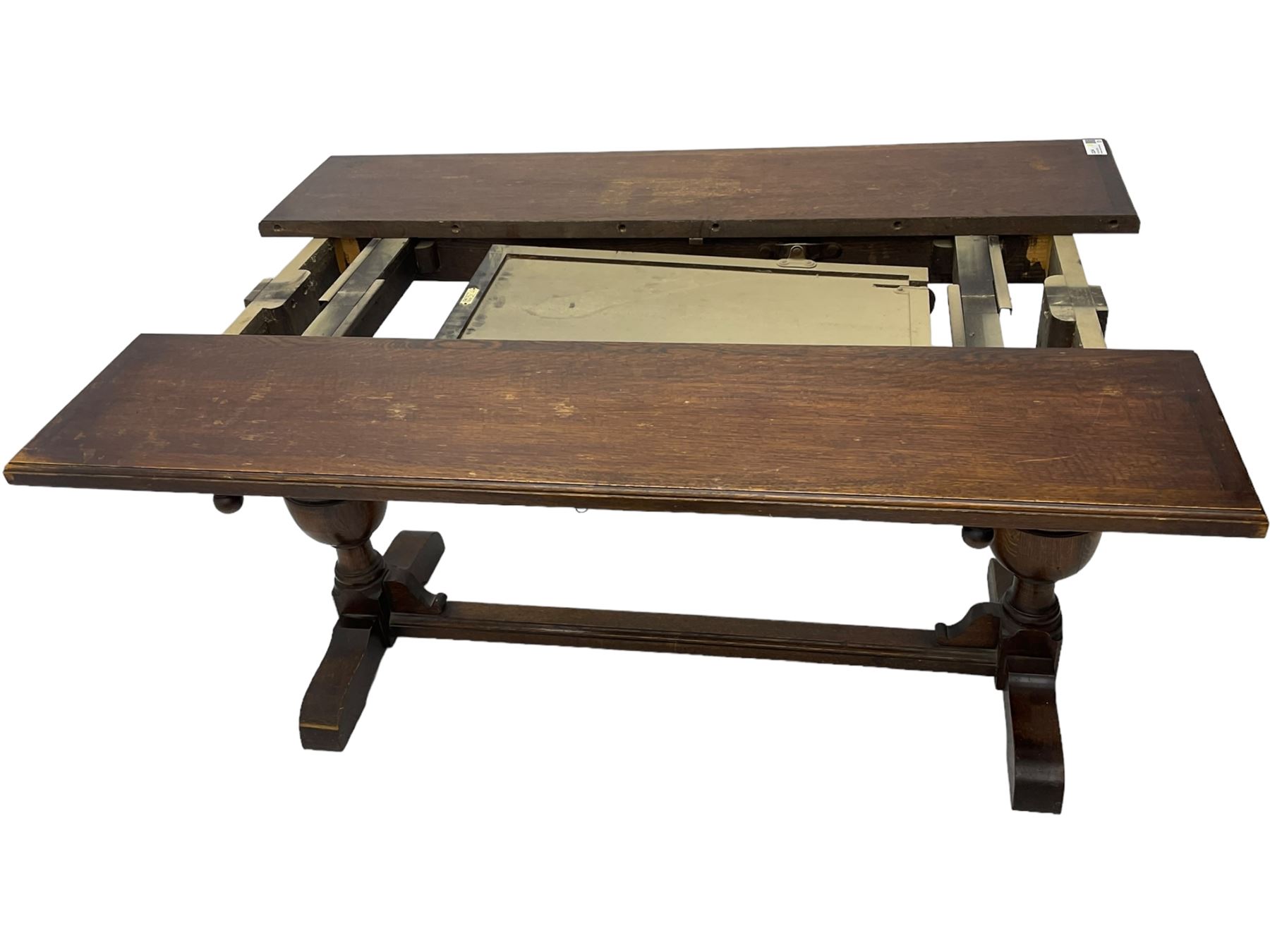 Early 20th century oak extending table, moulded rectangular top, pull-out action with fold-out leaf, on turned cup and cover pedestals and sledge feet, united by moulded stretcher 