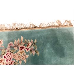 Chinese pale turquoise ground washed woolen rug, the plain field decorated with two large floral bouquet motifs with extending blossom and leafage