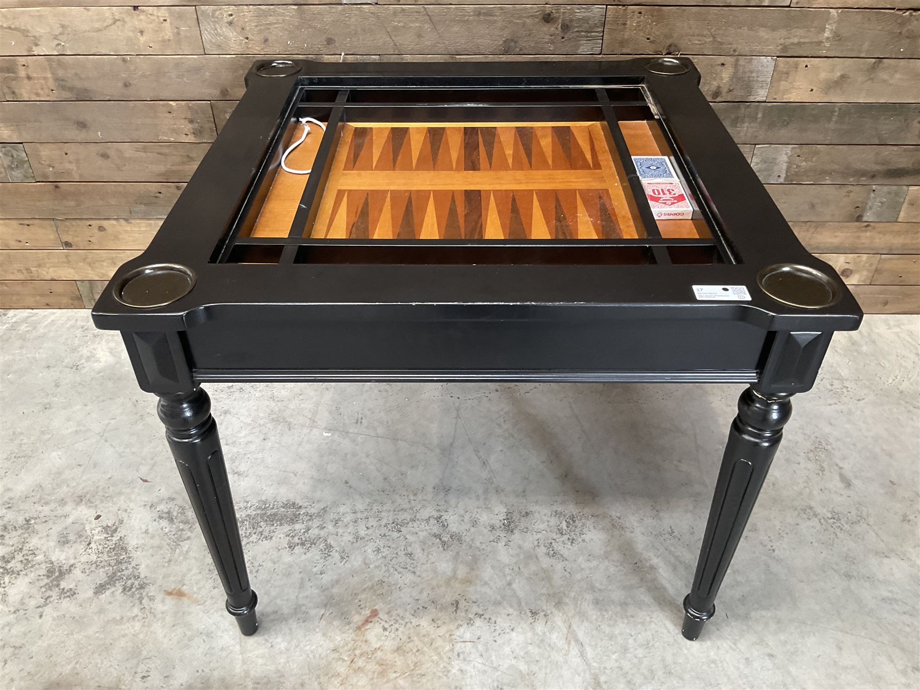 Ebonised square games table, reversible chessboard top revealing games compartment