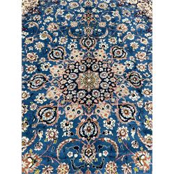 Persian Nain blue ground carpet, overall arabesque design, centre rosette medallion with eight projecting palmettes, the surrounding field decorated with interlacing branches and stylised plant motifs, within floral pale ground spandrels, the guarded border decorated with repeating stylised floral pattern 