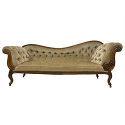 19th century walnut framed chaise longue, shaped back over scrolled arms decorated with moulded curling acanthus carvings, upholstered in deep buttoned champagne fabric, raised on cabriole supports with applied floral carved decoration, on castors