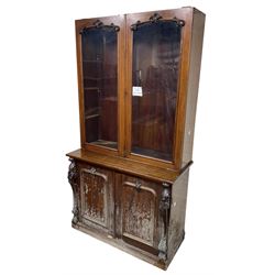 Victorian mahogany bookcase on cupboard, enclosed by two glazed doors, the base enclosed by two panelled doors flanked by acanthus carved upright pilasters, on plinth base