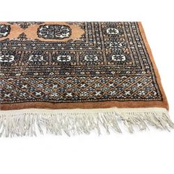 Afghan Bokhara rust ground rug, decorated with three columns of Gul motifs, the wide guard band with further scrolling and geometric designs (183cm x 129cm); together with a Persian design indigo ground rug (W170cm x 117cm)