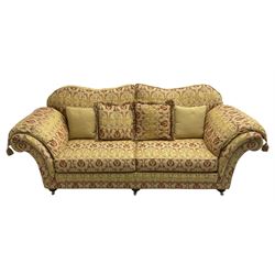 Steed Upholstery Ltd. - 'Lincoln' three-seat sofa upholstered in gold 'Olympia' floral pattern corded and tasselled fabric, together with scatter cushions and arm covers, on turned feet with brass castors