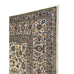 Persian Kashan ivory ground carpet, the field decorated with interlacing leafy branches and stylised plant motifs, repeating border with multiple guards