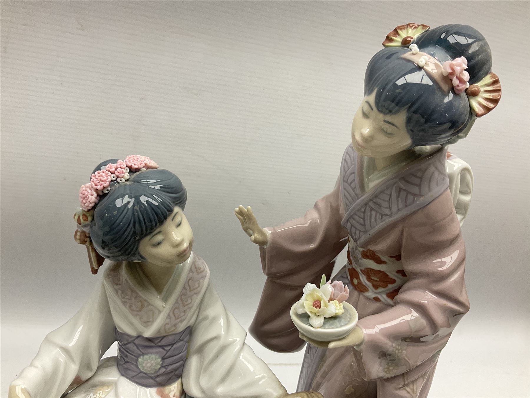 Lladro figure, Springtime in Japan, modelled as two Geisha on a bridge with a crane, sculpted by Salvador Debon, together with four Lladro flowers, Dahlia no 5180, White Camelia no 5181, White Carnation no 5184 and Chrysanthemum no 5189, largest example H32cm