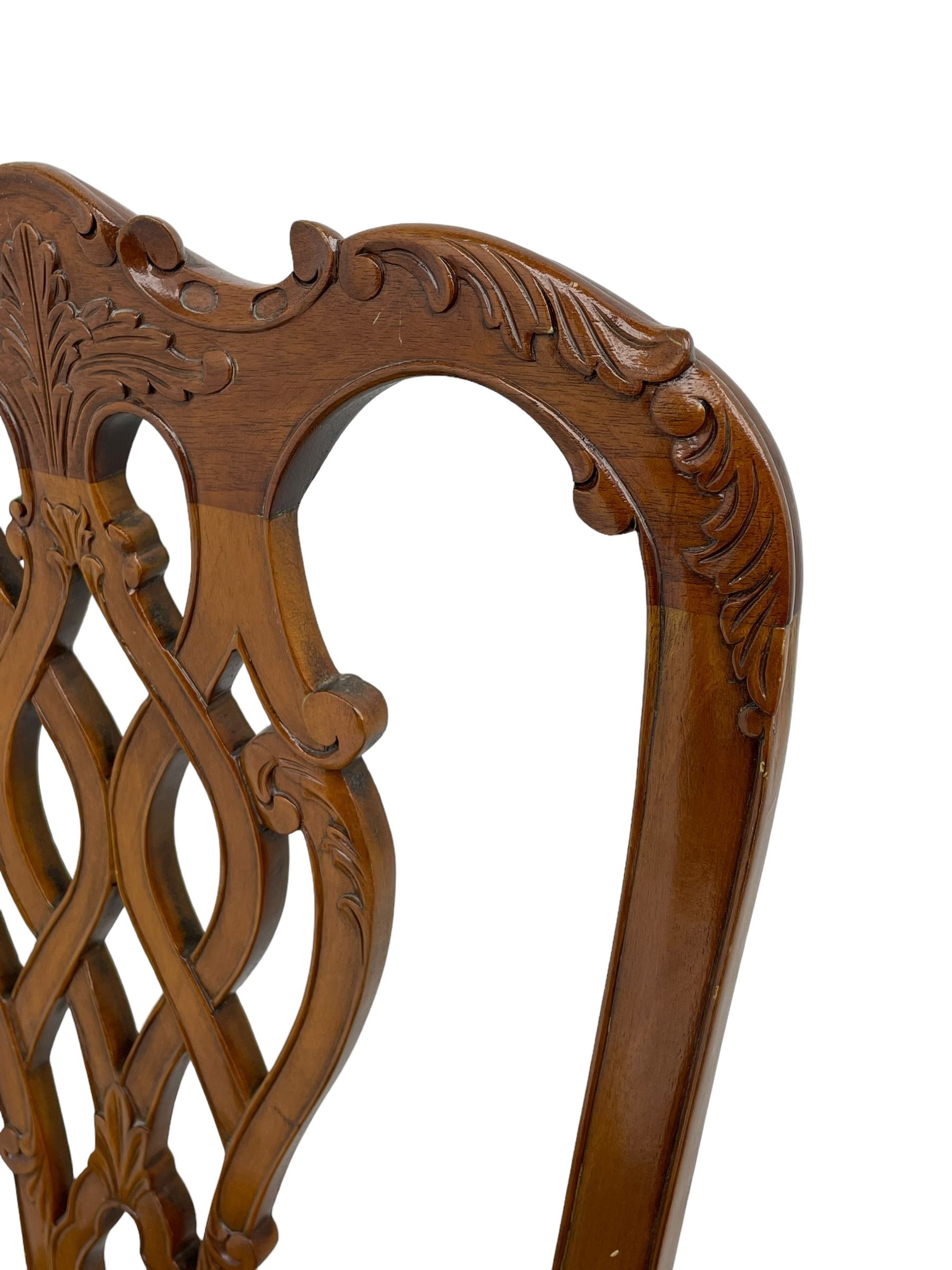 Set of twelve Chippendale design mahogany dining chairs, shaped cresting rail carved with foliage and C-scrolls, pierced interlaced splat with curled leaf decoration, upholstered drop-in seat, moulded seat rails, on scrolled acanthus carved cabriole supports with ball and claw feet 