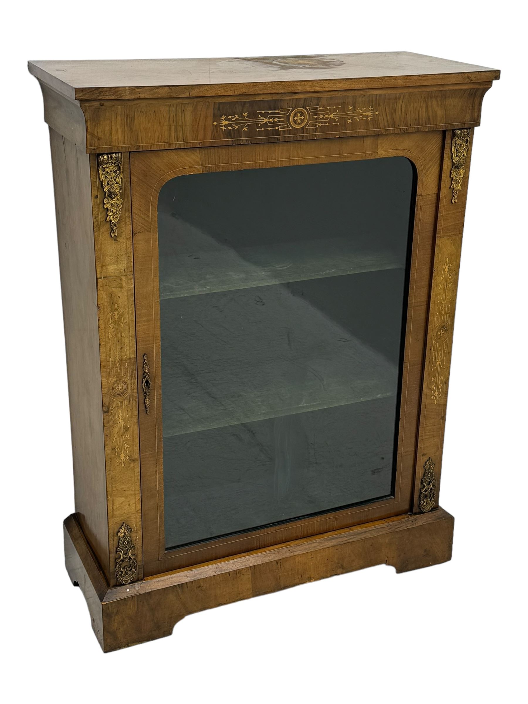 Late Victorian walnut pier cabinet, projecting cornice over frieze inlaid with foliate motifs, single glazed door flanked by ormolu mounts, enclosing shelved interior, on plinth base