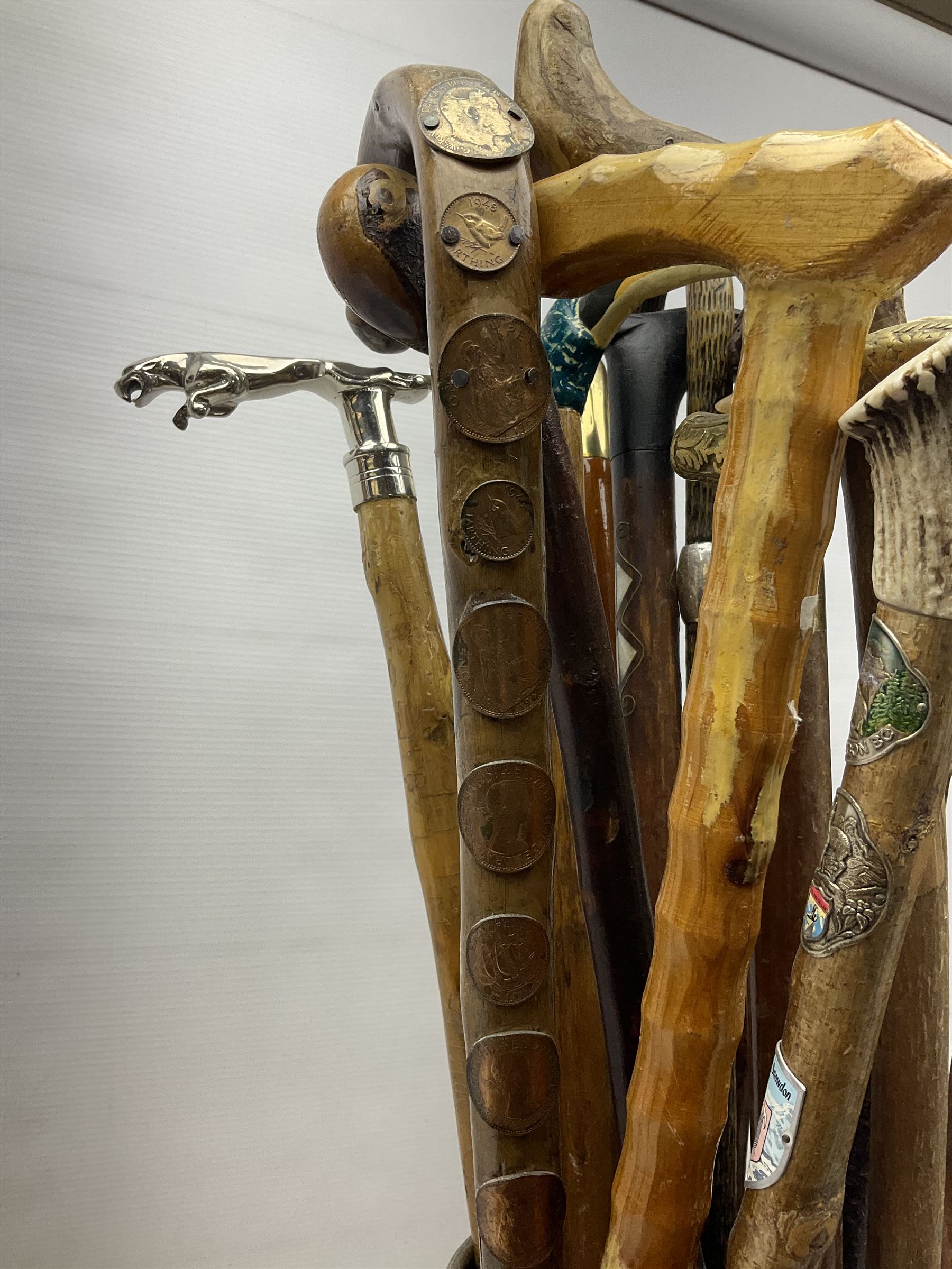 Oak barley twist stick stand, with a collection of walking sticks including examples with carved pommels, horn handles, silver collar etc, together with brass stick stand 