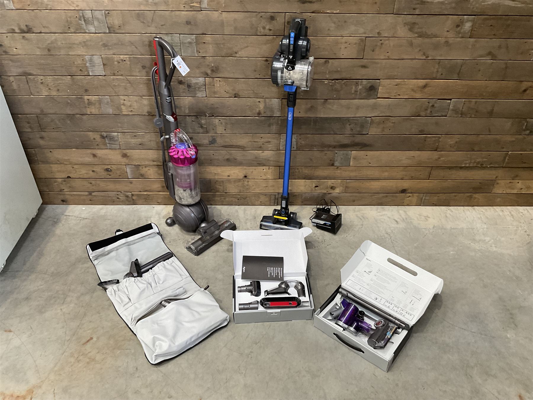 Dyson DC40 vacuum cleaner with various attachments, and a Vax cordless vacuum cleaner with single battery and charger