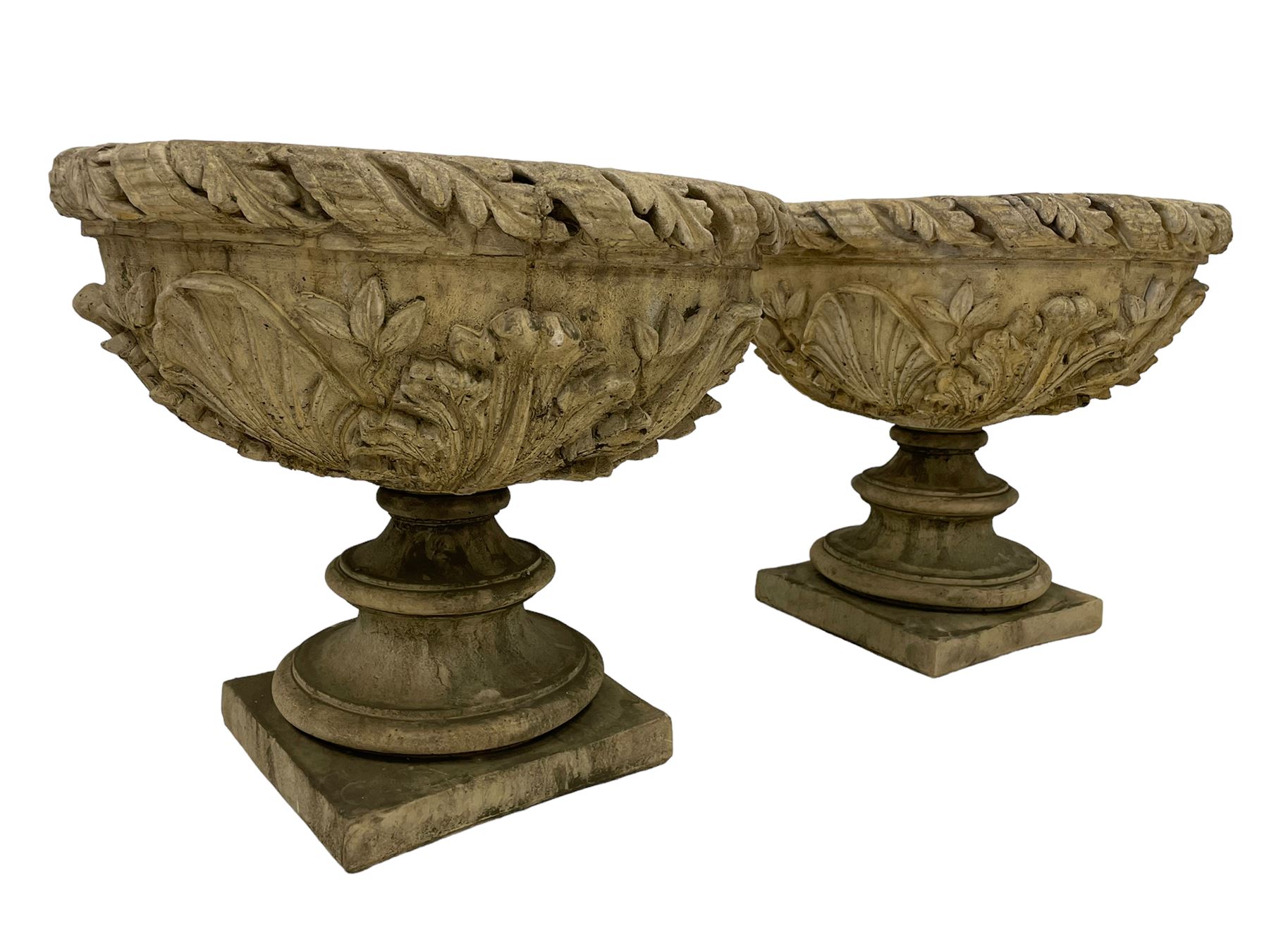 Pair of composite stone garden urn planters, acanthus leaf garland rim over foliate decorated body, stepped foot on square base