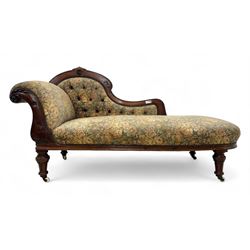 Victorian Aesthetic Movement mahogany framed chaise longue, shaped carved back over acanthus scrolled arm terminal, upholstered in floral patterned tapestry fabric with sprung seat, on turned and fluted supports with castors