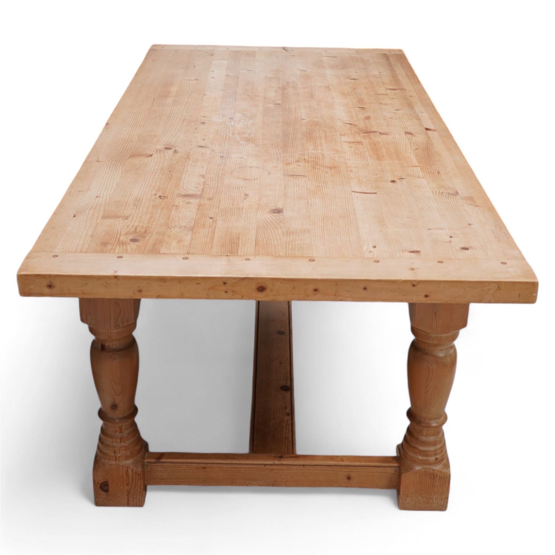 Waxed pine refectory table, boarded top with cleated ends, on turned supports united by H-stretchers 