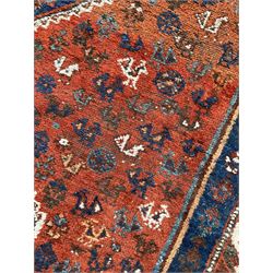 Persian Shiraz crimson ground rug, three connected lozenge medallions on a field decorated with small bird motifs, the main border decorated with repeating geometric motifs, within hooked guard stripes 