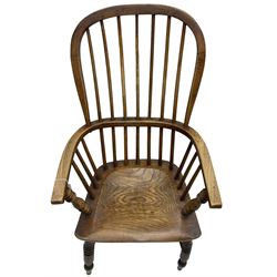 Early 19th century elm Windsor chair, high hoop and stick back over shaped saddle seat, raised on ring turned supports united by H-stretcher