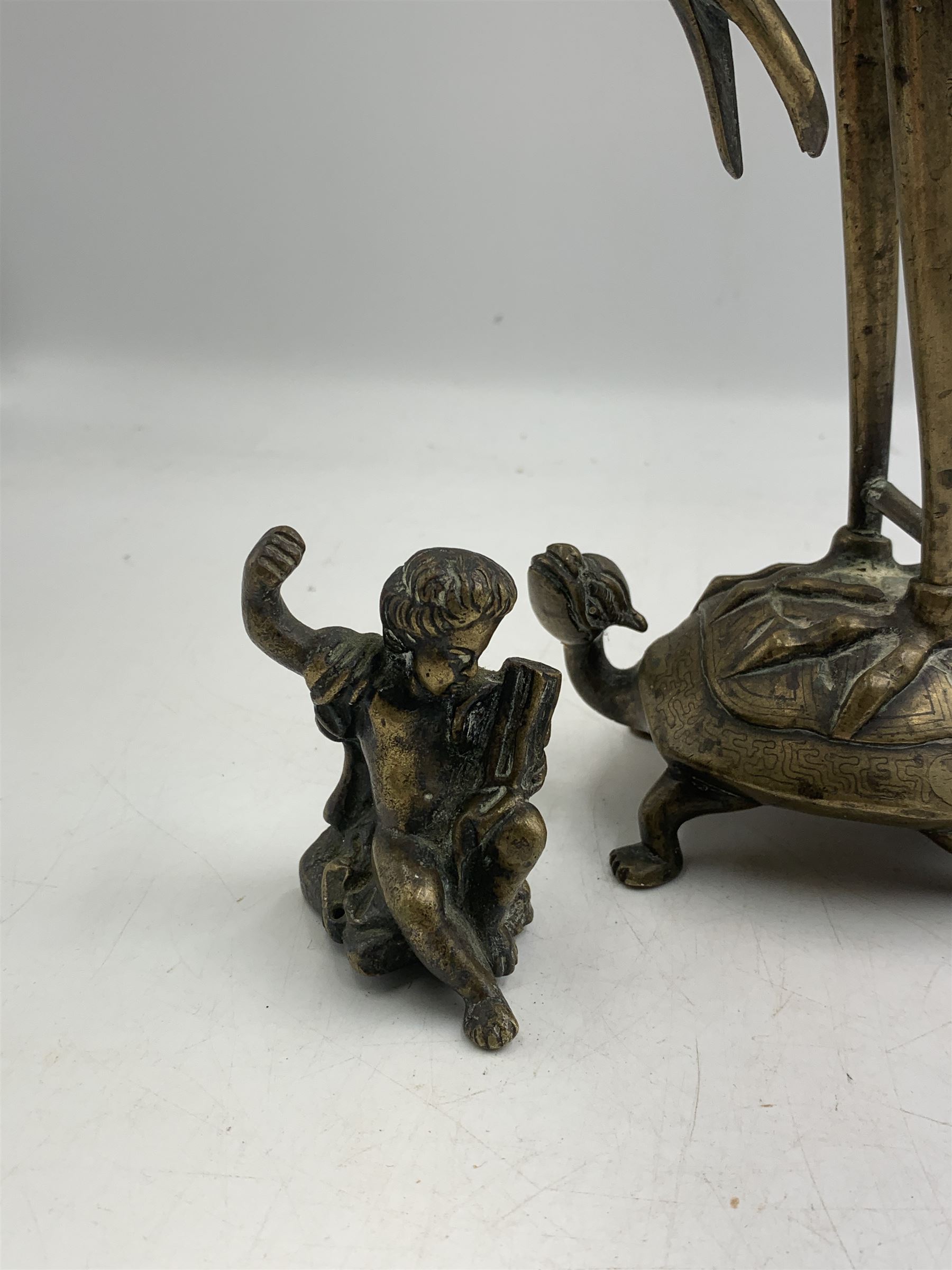 Early 20th century Japanese bronze figure or Okimono, modelled as a crane standing atop a turtle shell, possibly a candle holder, H25cm together with a small bronze figure modelled as a seated Cherub, H7cm (2)