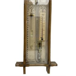 Admiral Fitzroy - Early 20th century Fitzroy barometer in a glazed gothic influenced oak case with chamfered uprights and top and base panels, full length paper scales with Fitzroy's observations and predictions, mercury bulb cistern, storm glass, spirit thermometer and brass sliding vernier pointers. Retailed by Inglis & Son, Coney Street, York.