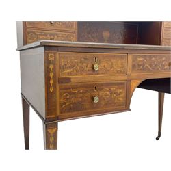 Edwardian inlaid mahogany writing desk, raised galleried back over inlaid central urn with scrolling leafy branches and six small drawers, satinwood banded rectangular moulded top with tooled leather inset, fitted with five drawers, the drawer facias inlaid with scrolling foliage and satinwood banding, square tapering supports inlaid with trailing bell flowers, on brass and ceramic castors 