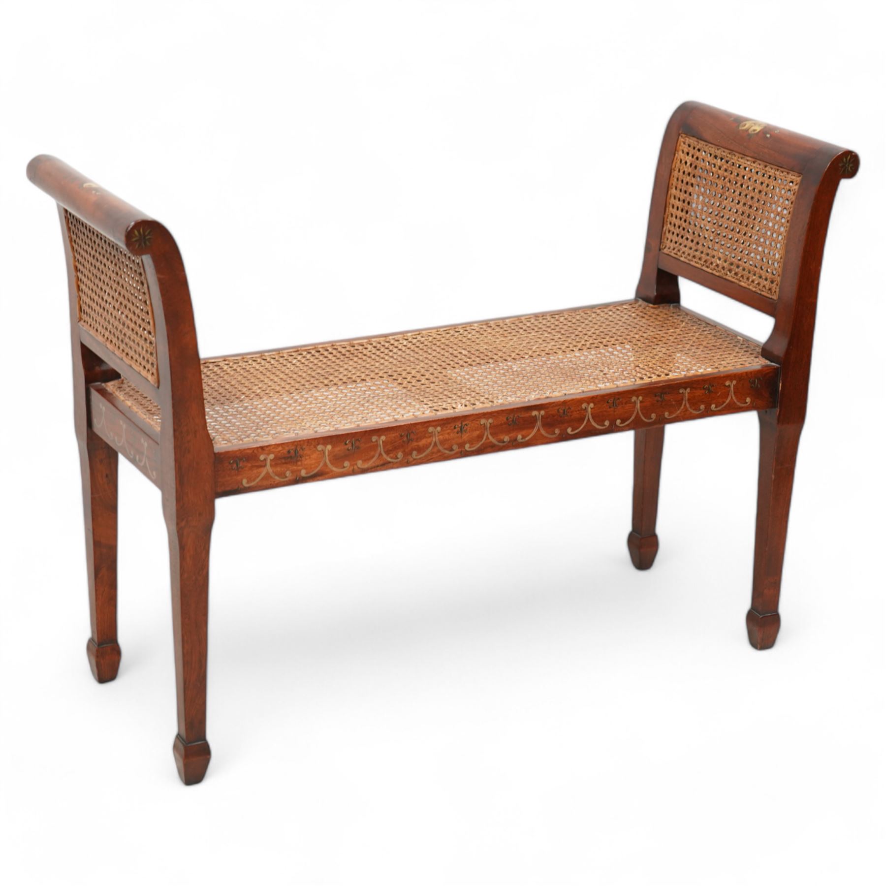 Regency design mahogany window seat, rolled uprights terminating to tapering supports with spade feet, cane work seat enclosed by double caned sides, with floral and C-scroll painted decoration 