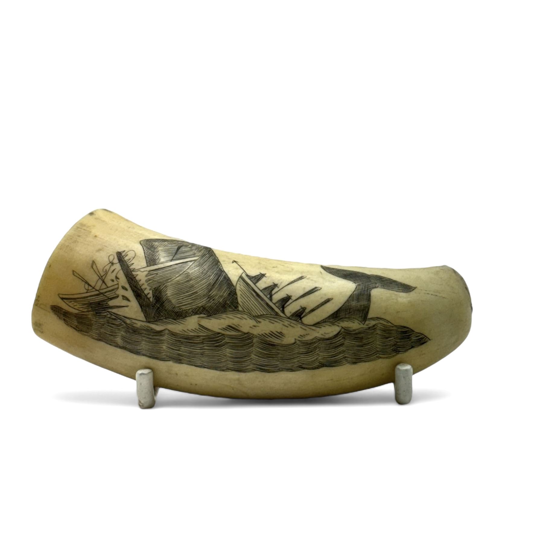 19th century scrimshaw whale tooth, depicting a whale destroying a boat, L9cm