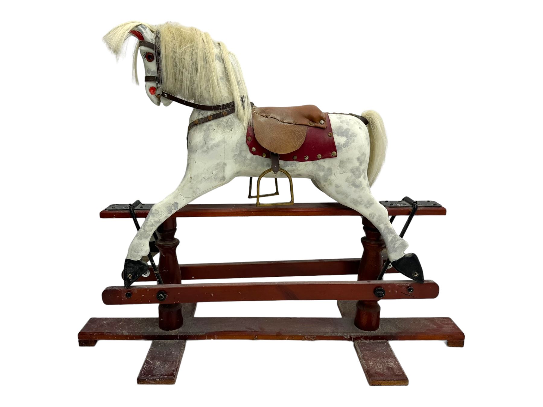 Mid 20th century rocking horse, dappled grey painted horse with applied mane and tail, red leather saddle and bridle accented with brass studs, supported by a stained wooden frame with turned supports and iron brackets, mounted on rockers