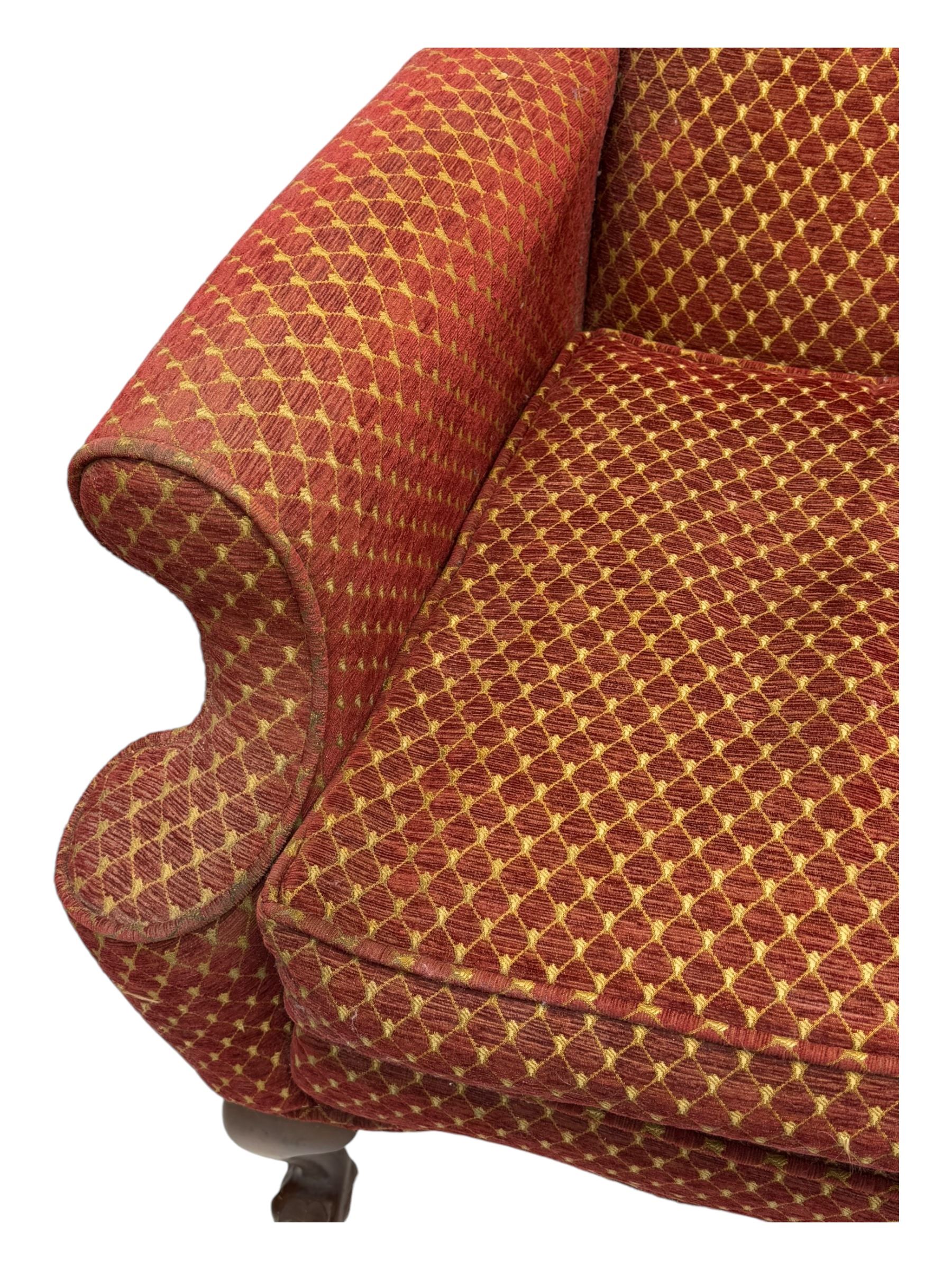 Early 20th century hardwood-framed wingback armchair, upholstered in red dotted fabric, on cabriole feet