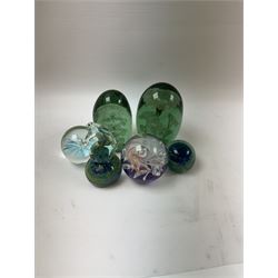 Two glass dump paperweights, with flower inclusions, together with four further glass paperweights