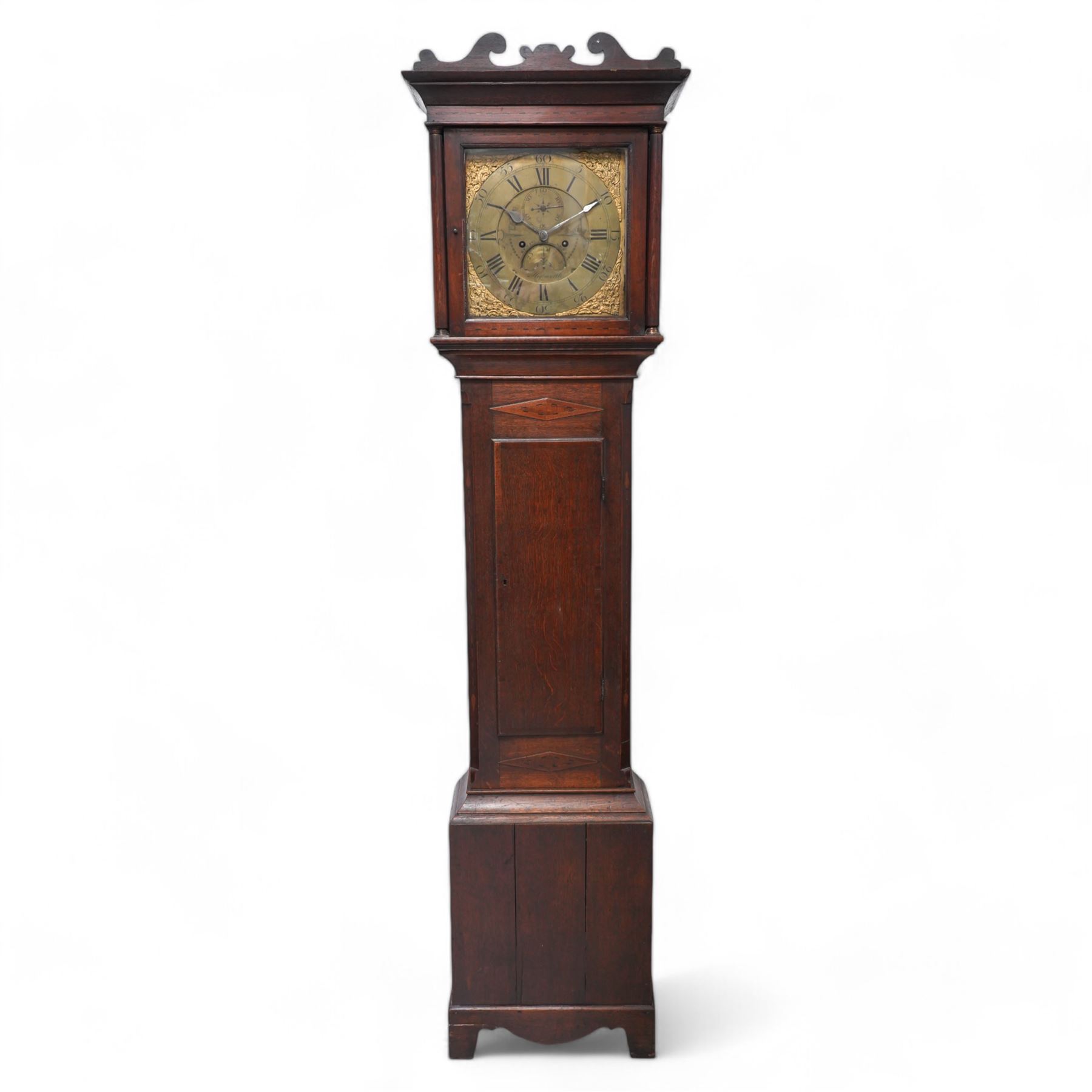 Benjamin Anns of Highworth (Wiltshire) - 8-day oak cased longcase clock c 1760 with a shaped pediment and square hood door beneath flanked by two pilasters with brass capitals, trunk with canted corners and a long flat topped door, on a rectangular plinth with applied decorative  skirting,  brass dial with an engraved dial centre, seconds dial, calendar aperture and steel spade hands, silvered chapter with Roman numerals and five minute Arabic's, dial pinned directly to a rack striking movement, striking the hours on a bell. With weights and pendulum.  