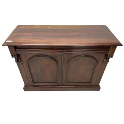 Victorian mahogany chiffonier, raised shaped back with foliage scroll carved mounts, on fretwork and carved bracket supports, moulded rectangular top over two frieze drawers and double panelled cupboard, on moulded plinth base