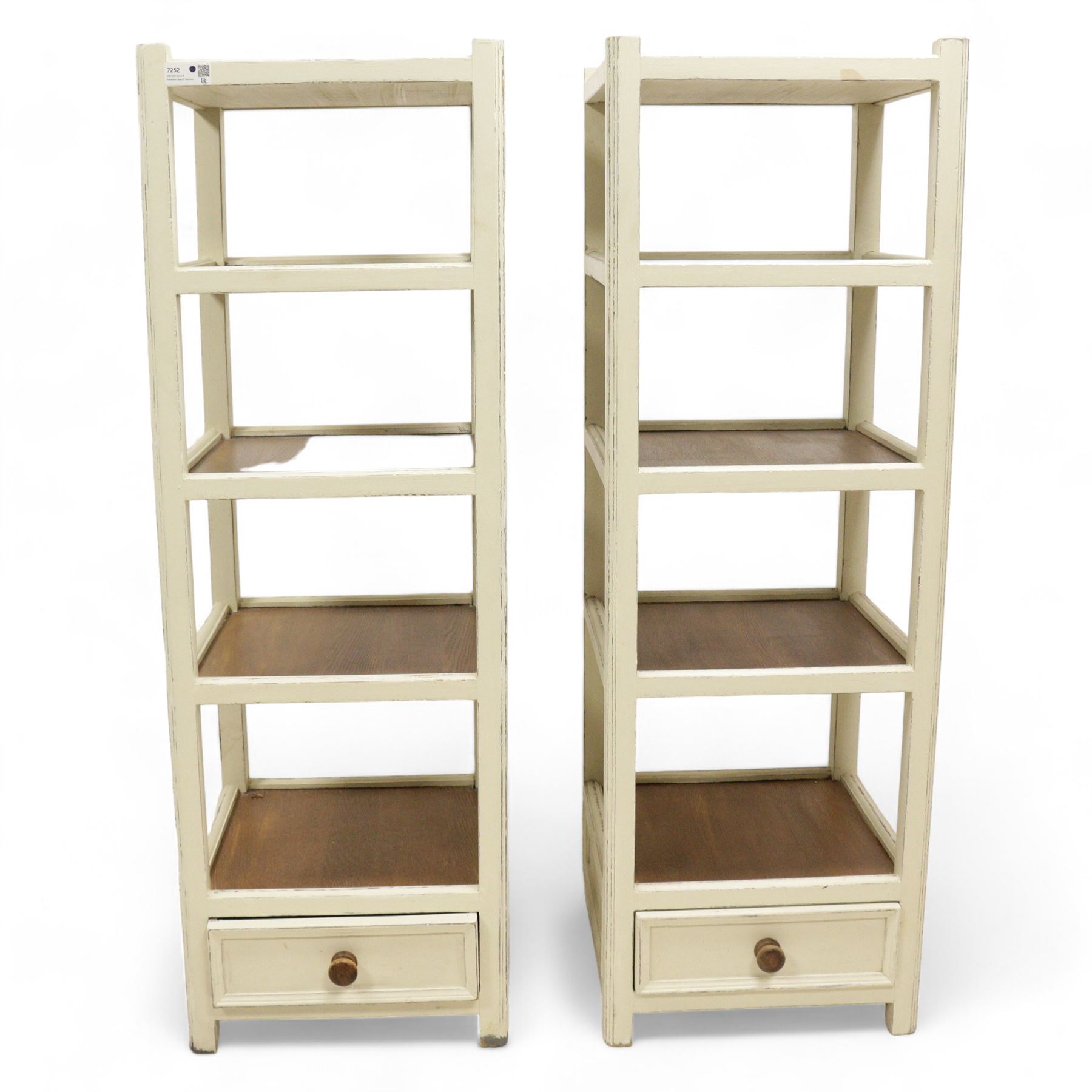 Pair of distressed cream painted and mahogany storage stands, five shelves with drawer to base