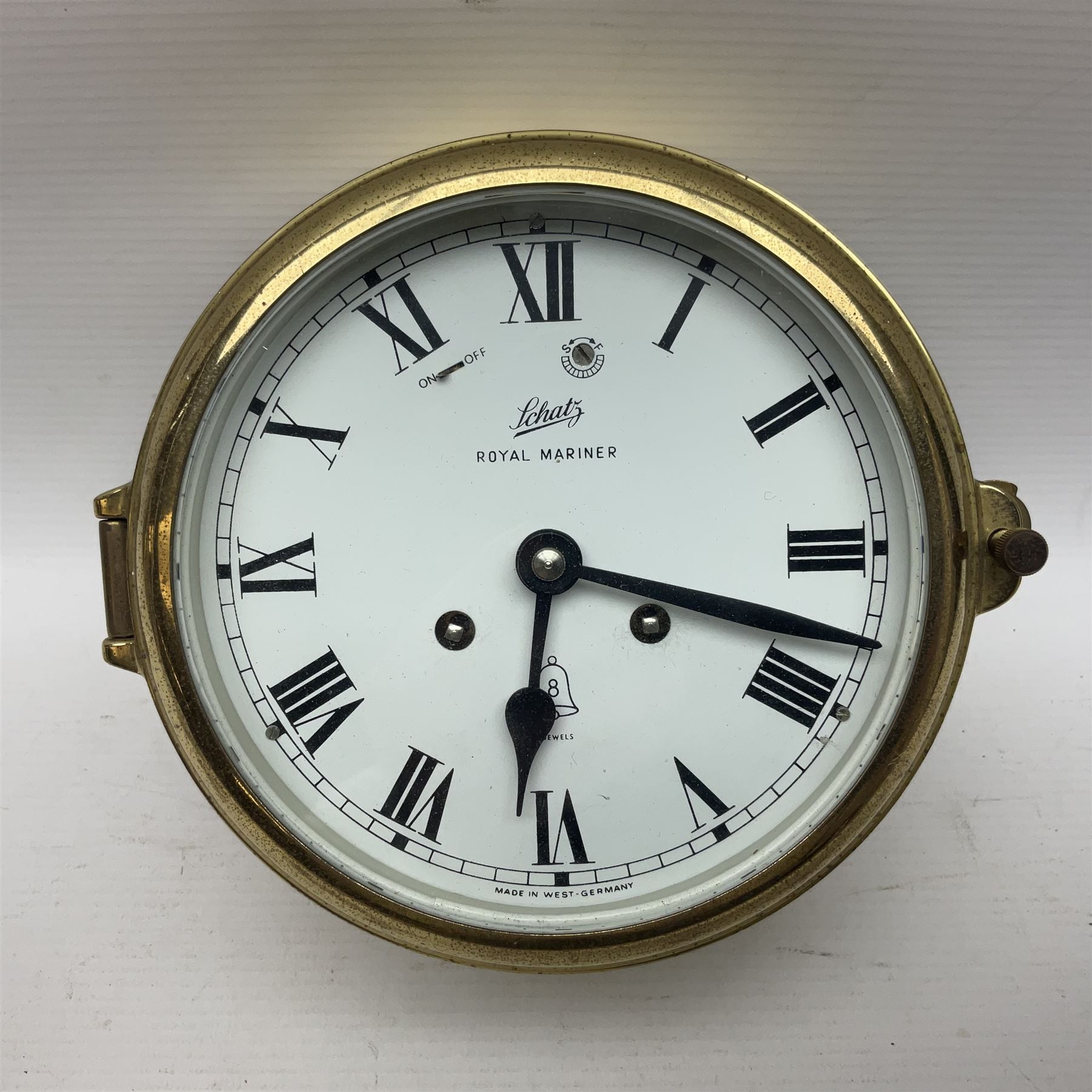 German Schatz Royal Mariner bulkhead ships clock, with an eight-day two-train platform seven-jewel movement, striking the ship's watch on a bell, with bells on/off facility and platform regulation on the 5 inch painted dial, with roman numerals and minute track, in brass case, case D16cm